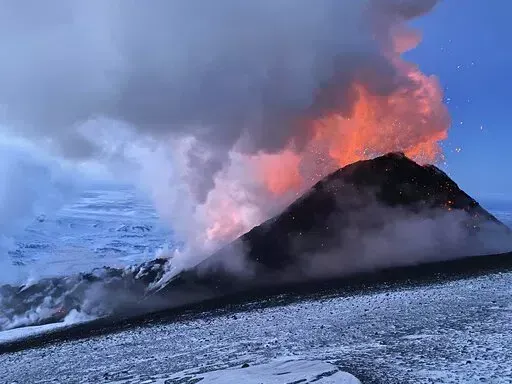 Flames and smoke billowing during the Klyuchevskaya volcano's eruption on the Kamchatka Peninsula in Russia, on March 8, 2021. Towering clouds of ash and glowing lava are spewing from two volcanoes on the Kamchatka Peninsula and scientists say major eruptions could be on the way. The sudden new activity followed a strong earthquake on Saturday Nov. 19, 2022, news reports said.  (AP Photo/Boris Smirnov, File)
