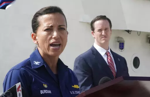 U.S. Coast Guard Captain Jo-Ann Burdian, foreground, speaks along with Homeland Security Investigations Special Agent in Charge in Miami Anthony Salisbury, rear, during a news conference, Thursday, Jan. 27, 2022, at Coast Guard Sector Miami in Miami Beach, Fla. The Coast Guard says it has found four more bodies in its search for dozens of migrants lost at sea off Florida, for a total of five bodies. The maritime security agency said Thursday that it also plans to call off its active search for s