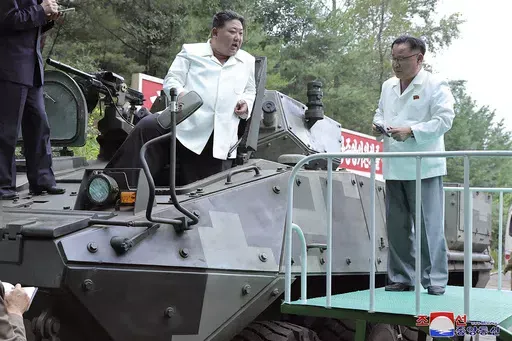 In this undated photo provided on Monday, Aug. 14, 2023, by the North Korean government, North Korean leader Kim Jong Un, center, rides on an armored vehicle during his Aug. 11-12 visit to a military factory in North Korea. Independent journalists were not given access to cover the event depicted in this image distributed by the North Korean government. The content of this image is as provided and cannot be independently verified. Korean language watermark on image as provided by source reads: "