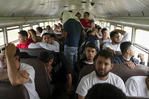 Honduran migrants who were deported from the U.S. sit on a bus after arriving at Ramon Villeda Morales Airport, in San Pedro Sula, Honduras, Wednesday, Dec. 4, 2024. (AP Photo/Moises Castillo)