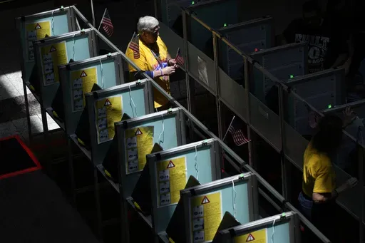 Poll workers help people vote in the Nevada primary at a polling place, Tuesday, June 11, 2024, in Henderson, Nev. (AP Photo/John Locher, File)