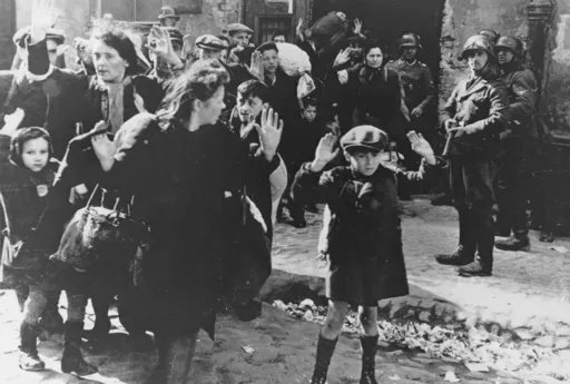 A group of Jews, including a small boy, is escorted from the Warsaw Ghetto by German soldiers on April 19, 1943. (AP Photo, File)