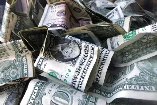 This April 3, 2019, file photo shows U.S. currency in New York. U.S. scientists have shown that payments to reduce poverty can enhance infants’ brain development in the first rigorous study of its kind. (AP Photo/Mark Lennihan, File)