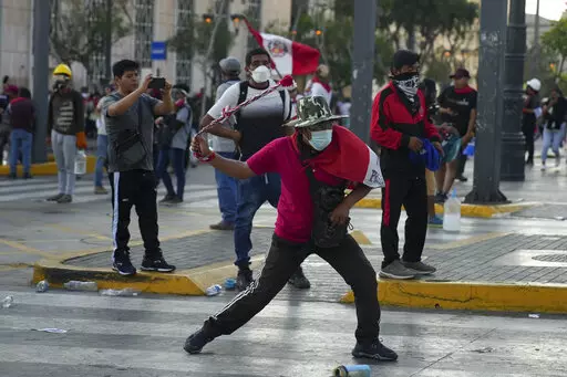 Anti-government protesters clash with police in Lima, Peru, Tuesday, Jan. 24, 2023. Protesters are seeking the resignation of President Dina Boluarte, the release from prison of ousted President Pedro Castillo, immediate elections and justice for demonstrators killed in clashes with police. (AP Photo/Guadalupe Pardo)