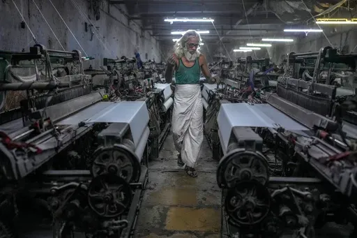 Abdul Sattar, 70, operates a power loom at a workshop in Bhiwandi, India, Feb. 25, 2025. (AP Photo/Rafiq Maqbool)