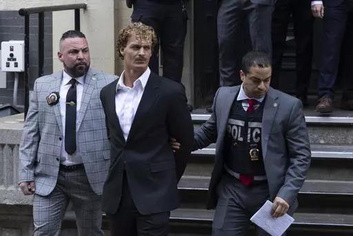Daniel Penny, center, is walked by New York Police Department detectives out of the 5th Precinct, May 12, 2023, in New York. Penny, the man charged with manslaughter for putting an agitated New York City subway rider in a fatal chokehold, has been indicted by a grand jury, an expected procedural step that will allow the criminal case to continue. (AP Photo/Jeenah Moon, File)