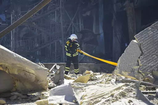 An Ukrainian firefighter works near a destroyed building on the outskirts of Odesa, Ukraine, Tuesday, May 10, 2022. The Ukrainian military said Russian forces fired seven missiles a day earlier from the air at the crucial Black Sea port of Odesa, hitting a shopping center and a warehouse.  (AP Photo/Max Pshybyshevsky)