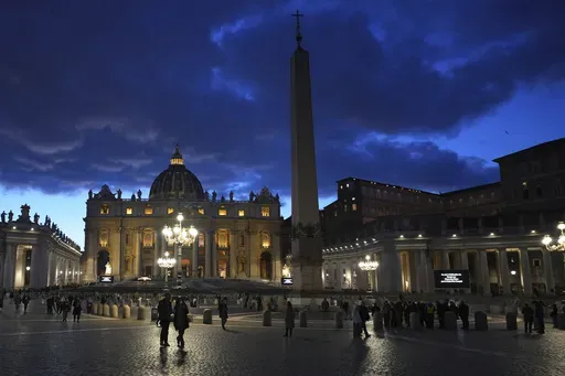 People walk at dusk in St Peter's Square at The Vatican, Thursday, Feb. 27, 2025. (AP Photo/Kirsty Wigglesworth, File)