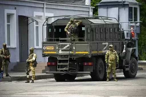 Russian soldiers guard an area as a group of foreign journalists visit in Kherson, Kherson region, south Ukraine, May 20, 2022. The southern city of Kherson was the first to fall to Russia's invasion. But Kherson remains at the heart of the conflict and Ukraine's efforts to save its vital access to the sea. (AP Photo, File)