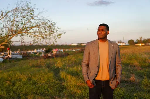 EPA Administrator Michael Regan poses for a photo for his EPA photographer near a cemetery in a neighborhood next to the Nu Star Energy oil storage tanks, after conducting a television interview, in St. James Parish, La., Nov. 16, 2021. Regan visited low-income, mostly minority communities in Mississippi, Louisiana and Texas as part of an effort to focus federal attention on communities adversely affected by decades of industrial pollution.  (AP Photo/Gerald Herbert, File)
