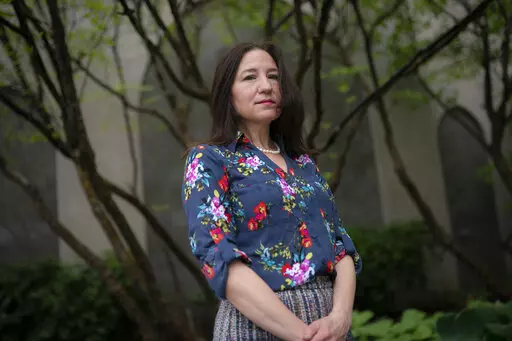 Allyson Jacobs stands for a portrait outside her workplace, Wednesday, May 4, 2022, in New York. For Jacobs, life in her 20s and 30s was about focusing on her career in health care and enjoying the club scene in New York City. It wasn't until she turned 40 that she and her husband started trying to have children. They had a son when she was 42.   (AP Photo/John Minchillo)