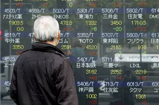 A person looks at an electronic stock board showing Japan's Nikkei 225 index at a securities firm, March 3, 2023, in Tokyo. Asian stock markets were mixed Thursday after the Federal Reserve said its economists expect a “mild recession” this year. (AP Photo/Eugene Hoshiko, File)