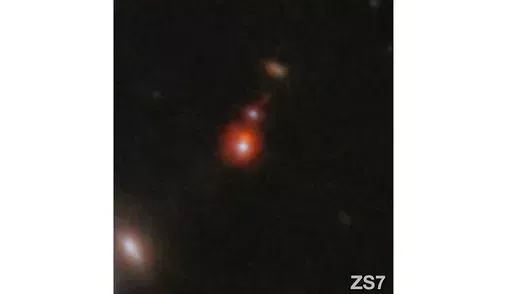 This image released by NASA shows the ZS7 galaxy system, revealing the ionized hydrogen emission in orange and the doubly ionized oxygen emission in dark red. (ESA/Webb, NASA via AP)
