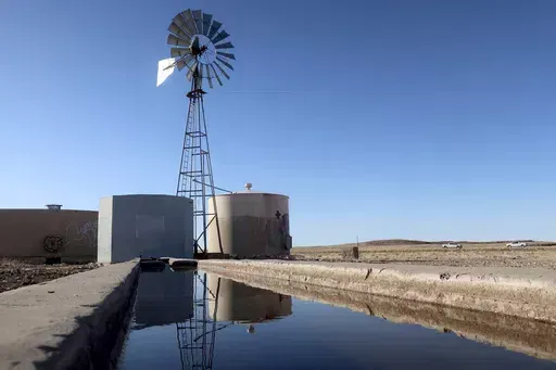 A windmill draws water for livestock in Leupp, Ariz., on the Navajo Nation, Saturday, March 9, 2024. In a vote on Thursday, May 23, 2024, the Navajo Nation Council has unanimously approved a proposed water rights settlement that carries a price tag larger than any such agreement enacted by Congress. (AP Photo/Felicia Fonseca, File)