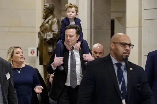 Elon Musk, President-elect Donald Trump's pick for the planned Department of Government Efficiency, carries his son X Æ A-Xii on his shoulders, following a meeting with members of Congress at the Capitol, Thursday, Dec. 5, 2024, in Washington. (AP Photo/Rod Lamkey, Jr.)