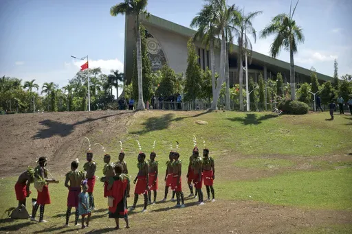 Performers in traditional dresses stand outside of Parliament Haus in Port Moresby, Papua New Guinea, on Nov. 16, 2018. At least 26 people has been reported killed by a gang of men in three remote villages last week in Papua New Guinea's north, United Nations and police officials said on Wednesday, July 24, 2024. (AP Photo/Mark Schiefelbein, FILE)