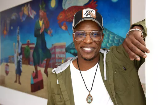 Nate Looney poses in front of a painting at the BAR Center at the Beach Thursday, June 16, 2022, in the Venice section of Los Angeles. Looney is a Black man who grew up in Los Angeles, a descendant of enslaved people from generations ago. He's also an observant, kippah-wearing Jew. (AP Photo/Mark J. Terrill)