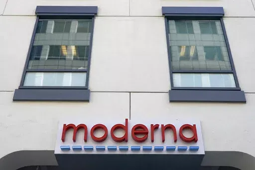 In this Dec. 15, 2020, file photo, a sign for Moderna, Inc. hangs on its headquarters in Cambridge, Mass.  Moderna's experimental COVID-19 vaccine that combines its original shot with protection against the omicron variant appears to work, the company announced Wednesday, June 8, 2022.  COVID-19 vaccine makers are studying updated boosters that might be offered in the fall to better protect people against future coronavirus surges.(AP Photo/Elise Amendola, File)