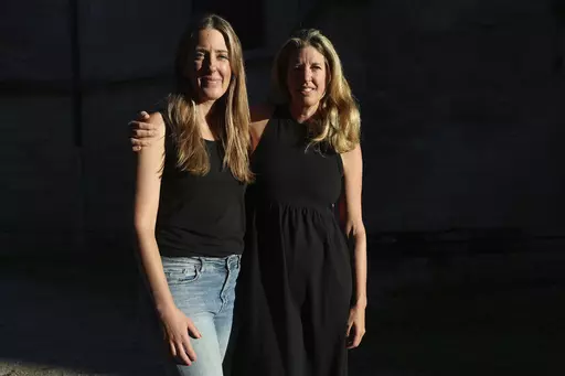 Hillary Jackson, from New York, right, and Kristy Benner, from Los Angeles, pose outside the Saint-Andre hospital in Bordeaux, southwestern France, Thursday, Sept.14, 2023. Kristy Benner's partner Matt Jackson was riding an electric bike through Bordeaux wine country on vacation when he started feeling strange. Nine days later, he's on a breathing machine in a French ICU, unable to open his eyes, communicating only via notes on a whiteboard and infected with botulism. A 32-year-old woman died in
