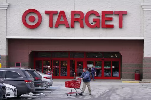 A shopper wheels his shopping cart through the parking lot after making a purchase at the Target store, Monday, Feb. 27, 2023, in Salem, N.H. Target reported on Tuesday, Feb. 28, a 43% drop in profits and a slight uptick in sales for the holiday quarter, reflecting the discounter's ongoing challenges of cautious consumer spending and its own higher costs. (AP Photo/Charles Krupa)