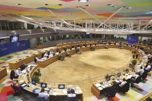 Ukrainian President Volodymyr Zelenskyy is seen on a screen, left, as addresses from Kyiv during an extraordinary meeting of EU leaders to discuss Ukraine, energy and food security at the Europa building in Brussels, Monday, May 30, 2022. European Union leaders will gather Monday in a fresh show of solidarity with Ukraine but divisions over whether to target Russian oil in a new series of sanctions are exposing the limits of how far the bloc can go to help the war-torn country. (AP Photo/Olivier
