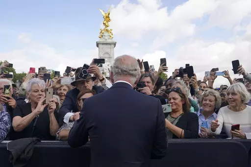 Britain's King Charles III, back to camera, greets well-wishers as he walks by the gates of Buckingham Palace following Thursday's death of Queen Elizabeth II, in London, Friday, Sept. 9, 2022. King Charles III will be crowned Saturday, May 6, 2023 at Westminster Abbey in an event full of all the pageantry Britain can muster. (Yui Mok/Pool Photo via AP, File)