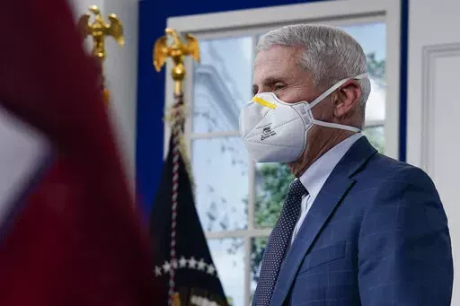 Dr. Anthony Fauci, the top U.S. infectious disease expert, wears a face mask as he arrives for the the White House COVID-19 Response Team's regular call with the National Governors Association in the South Court Auditorium in the Eisenhower Executive Office Building on the White House Campus, Monday, Dec. 27, 2021, in Washington. Fauci says the U.S. should consider a vaccination mandate for domestic air travel as coronavirus infections surge. To date the Biden administration has balked at the id