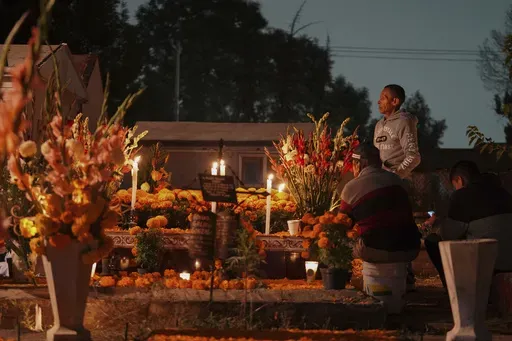 Families gather by the tomb of their dearly departed, as they celebrate the Day of the Dead, at the San Gregorio Atlapulco cemetery on the outskirts of Mexico City, Friday, Nov. 1, 2024. (AP Photo/Moises Castillo)