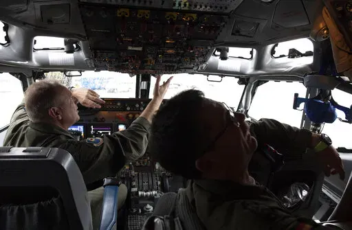 Pilots work in the cockpit of an AWACS plane at Melsbroek military airport in Melsbroek, Belgium, Wednesday, Nov. 27, 2019. As Russia’s military buildup near Ukraine accelerated early this year, military planners at NATO began preparing to dispatch scores of fighter jets and surveillance aircraft into the skies near Russia and Ukraine. It was a warning to Moscow not to make the mistake of targeting any member country. (AP Photo/Virginia Mayo, File)