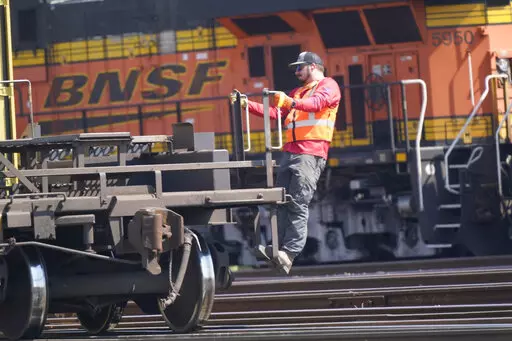 A worker rides a rail car at a BNSF rail crossing in Saginaw, Texas, Wednesday, Sept. 14, 2022. Most railroad workers weren't surprised that Congress intervened this week to block a railroad strike, but they were disappointed because they say the deals lawmakers imposed didn't do enough to address their quality of life concerns about demanding schedules and the lack of paid sick time. (AP Photo/LM Otero, File)