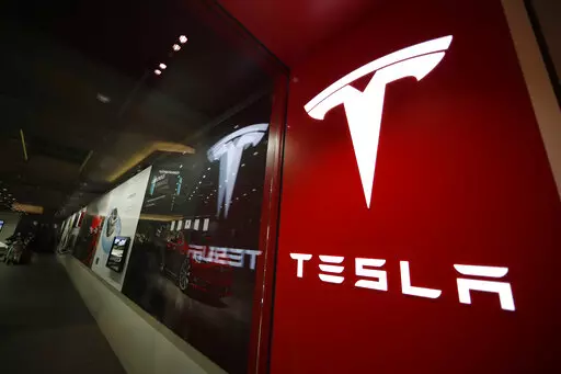 A Tesla logo is seen at the company's store in Denver's Cherry Creek Mall on Feb. 9, 2019. Owning Tesla stock in 2022 has been anything but a smooth ride for investors. Shares in the electric vehicle maker are down nearly 70% since the start of the year, on pace to finish in the bottom five biggest decliners among S&P 500 stocks. (AP Photo/David Zalubowski, File)