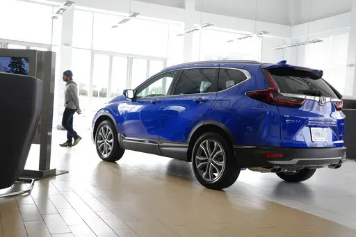 A potential buyer surveys a 2022 CR-V sports-utility vehicle on the showroom floor of a Honda dealership, Thursday, Nov. 3, 2022, in Highlands Ranch, Colo. (AP Photo/David Zalubowski, File)