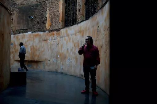 Jonatan, 26, smokes a cigarette in a designated area of the Bepo Ghezzi Social Inclusion Center, in the Parque Patricios neighborhood of Buenos Aires, Argentina, Thursday, Sept. 21, 2023. Jonatan said he would be sleeping on the streets if it weren't for the city-run shelter where in addition to a bed, hot showers and four meals a day, residents receive psychological support and training to reenter the workforce. (AP Photo/Natacha Pisarenko)
