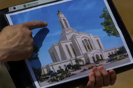 Bud Stoddard, a regional church leader, holds a rendering of the temple planned by The Church of Jesus Christ of Latter-day Saints at a site near Las Vegas, May 16, 2024. (AP Photo/Ty ONeil)