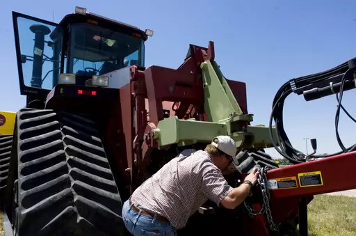Farmer Nathan Weathers configures a high-power, high-tech quad-track tractor near his farm in Yuma, Colo, June 30, 2008. Lawmakers in Colorado and 10 other states have introduced bills that would force farming equipment manufacturers to provide the tools, software, parts and manuals needed for farmers to do their own repairs. The bills are a response to farmers unable to repair their own tractors and combines, forcing them to wait sometimes days and paying steep labor costs. (Brian Brainerd/The 