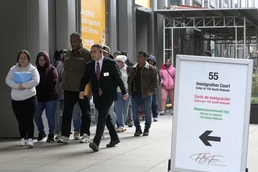 After waiting in a cue, people are led into a downtown Chicago building where an immigration court presides Tuesday, Nov. 12, 2024, in Chicago. (AP Photo/Charles Rex Arbogast, File)