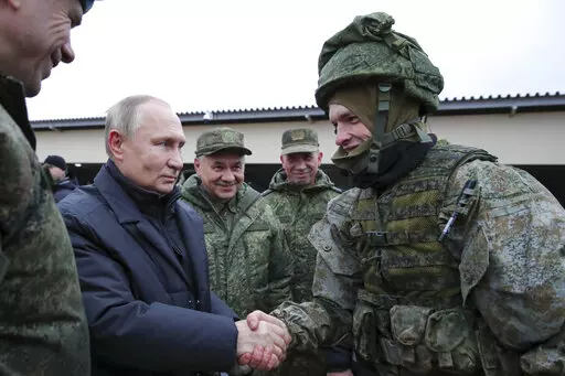 Russian President Vladimir Putin shakes hands with a soldier as he visits a military training centre of the Western Military District for mobilised reservists as Russian Defense Minister Sergei Shoigu, center, smiles in Ryazan Region, Russia, Thursday, Oct. 20, 2022. The mobilized reservists that Russian President Vladimir Putin visited last week at a firing range southeast of Moscow looked picture-perfect. (Mikhail Klimentyev, Sputnik, Kremlin Pool Photo via AP, File)