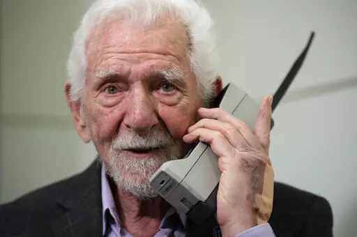 Marty Cooper, the inventor of first commercial mobile phone, poses for the press with a Motorola DynaTAC 8000x, during an interview with The Associated Press at the Mobile World Congress 2023 in Barcelona, Spain, Monday, Feb. 27, 2023. The four-day show kicks off Monday in a vast Barcelona conference center. It's the world's biggest and most influential meeting for the mobile tech industry. (AP Photo/Joan Mateu Parra)