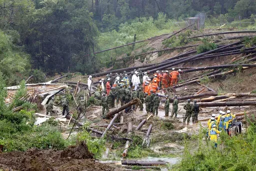 Rescuers conduct a search operation at the site of a landslide in Mimata, Miyazaki Prefecture, southern Japan, Monday Sept. 19, 2022. Powerful Typhoon Nanmadol slammed ashore in southern Japan on Sunday as it pounded the region with strong winds and heavy rain, causing blackouts, paralyzing ground and air transportation and prompting the evacuation of thousands of people. (Kyodo News via AP)