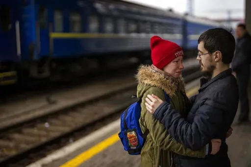 A couple says goodbye before she boards on a train bound for Lviv at the Kyiv station, Ukraine, Thursday, March 3. 2022. (AP Photo/Emilio Morenatti)