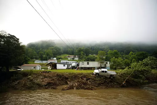 A truck sits on the edge over a river, Thursday, July 14, 2022 in Whitewood, Va., after being swept away in a flash flood . Virginia Gov. Glenn Youngkin declared a state of emergency to aid in the rescue and recovery efforts from Tuesday's floodwaters. (AP Photo/Michael Clubb)
