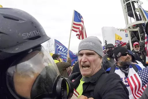 In this image from video, Alan William Byerly, center, attacks an Associated Press photographer during a riot at the U.S. Capitol in Washington, Jan. 6, 2021. On Sunday, Oct. 9, 2022, federal prosecutors recommended a prison sentence of nearly four years for Byerly, of Pennsylvania, who pleaded guilty to assaulting the AP photographer and using a stun gun against police officers during a mob's attack on the U.S. Capitol. (AP Photo/Julio Cortez, File)