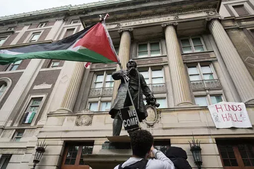 A student protester parades a Palestinian flag outside the entrance to Hamilton Hall on the campus of Columbia University, Tuesday, April 30, 2024, in New York. The student-run legal journal, Columbia Law Review, was taken offline Monday, June 3, 2024, after its board of directors objected to the publication of an article that accused Israel of genocide. (AP Photo/Mary Altaffer, Pool, File)