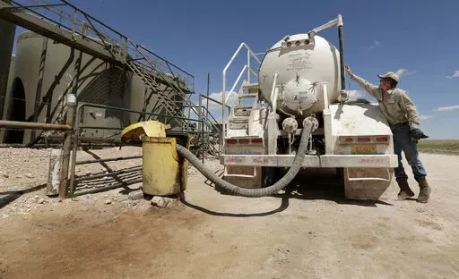 In this April 24, 2015, filephoto, a worker empties oilfield wastewater from a tank truck into storage tanks on Carl and Justin Johnson's ranch near Crossroads, N.M. Labor shortages, supply problems and volatile prices have made oil companies cautious about new drilling even as U.S. politicians push for increased production. (AP Photo/Charlie Riedel, File)