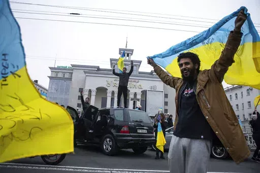 Ukrainians gather in downtown to celebrate the recapturing their city, Kherson, Ukraine, Saturday, Nov. 12, 2022. Amid the death and destruction war leaves in its wake, there are powerful dynamics and narratives: domination, besieged populations, occupation and their counterparts, resistance, freedom and liberation. Vast swaths of Western and Eastern Europe and the Soviet Union knew this well at various points of the 20th century. (AP Photo/Yevhenii Zavhorodnii, File)