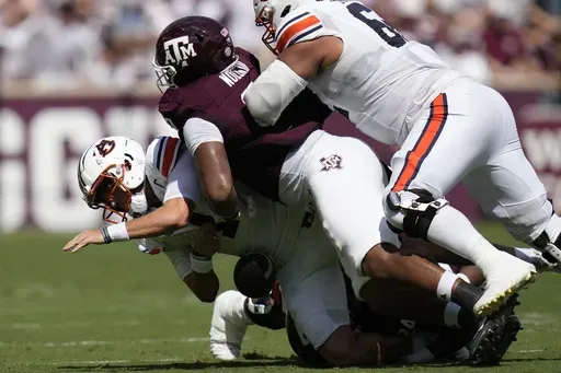 Auburn quarterback Payton Thorne, left, is sacked by then-Texas A&M defensive lineman Walter Nolen, right, and linebacker Chris Russell Jr., bottom, during the first half of an NCAA college football game Saturday, Sept. 23, 2023, in College Station, Texas. (AP Photo/Sam Craft, File)