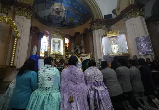 Devotees pray after dressing the statue of "Jesus del Gran Poder" or Lord of Great Power, at the "Jesus del Gran Poder" church in La Paz, Bolivia, Thursday, June 1, 2023. Thousands of dancers and musicians will parade on Saturday to show their devotion and thank God and for the year's blessings. (AP Photo/Juan Karita)