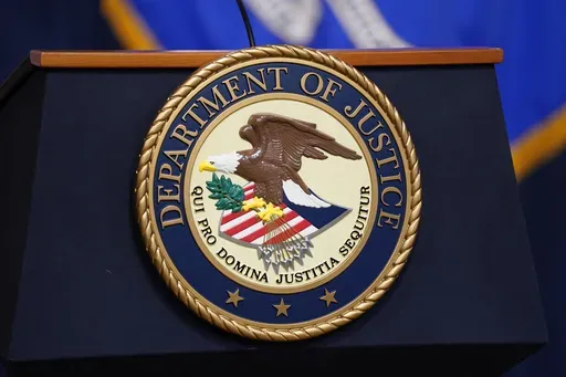 The seal for the United States Department of Justice is displayed on a podium before a news conference at the Justice Department in Washington, Thursday, April 13, 2023. (AP Photo/Evan Vucci, File)