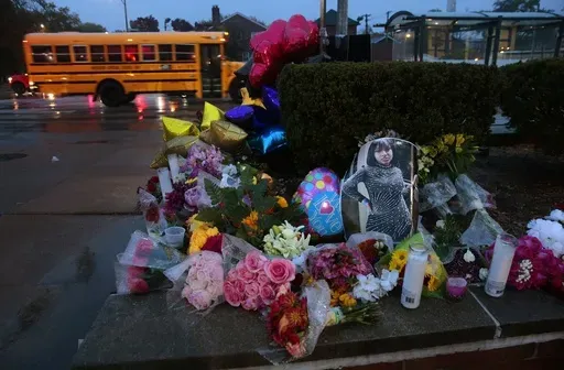 A photo of Alexandria Bell rests at the scene of a growing floral memorial to the victims of a school shooting at Central Visual & Performing Arts High School, Oct. 25, 2022, in St. Louis. (Robert Cohen/St. Louis Post-Dispatch via AP, File)