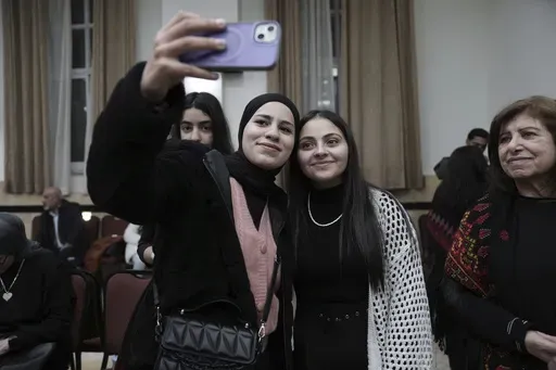 Dania Hanatsheh, right, a former Palestinian prisoner who was released from an Israeli prison as part of a ceasefire deal between Israel and Hamas, poses for a photo at a reception for released prisoners, West Bank city of Ramallah, Monday, Jan. 20, 2025. (AP Photo/Mahmoud Illean)